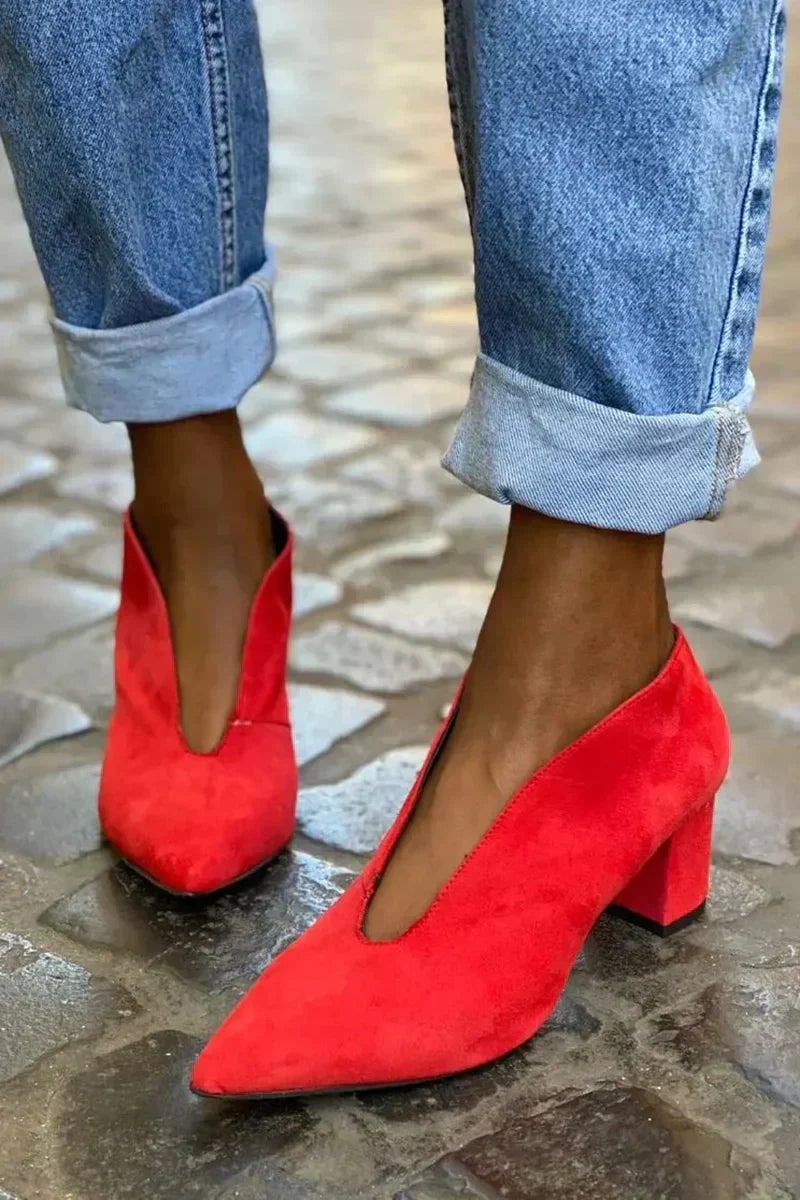 Red suede block heel pumps with pointed toe and deep V vamp worn with rolled up jeans