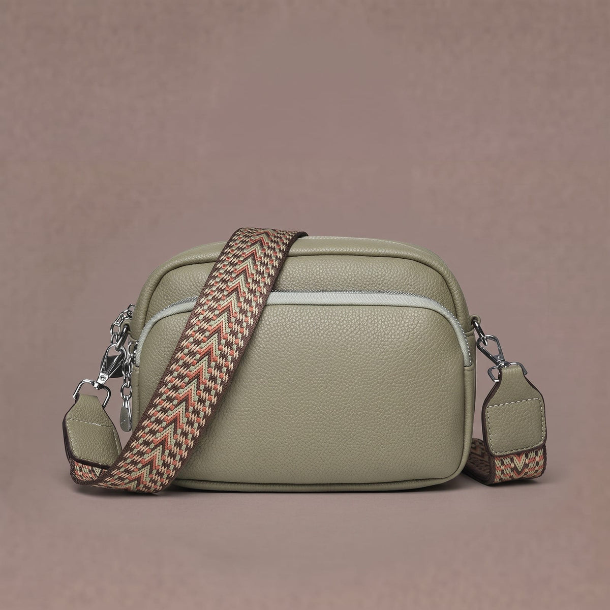 Sage green crossbody bag with wide woven strap and front zip pocket