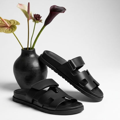 Black flat leather slide sandals with cut out straps, pair