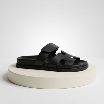 Black flat leather slide sandal, side view
