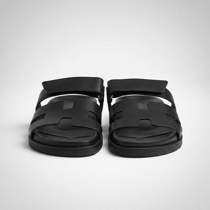 Black flat leather slide sandals, front view