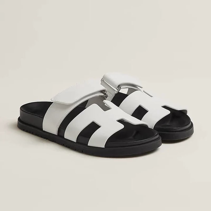 White flat slide sandals with black sole and adjustable strap