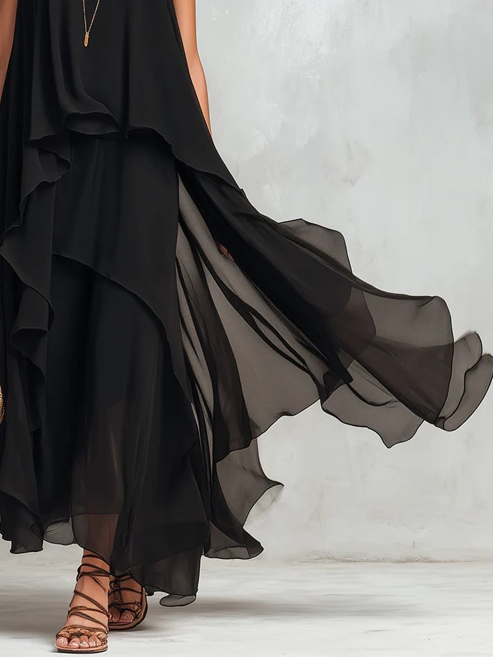 Close view of the sheer tiered skirt of the black layered maxi dress in motion