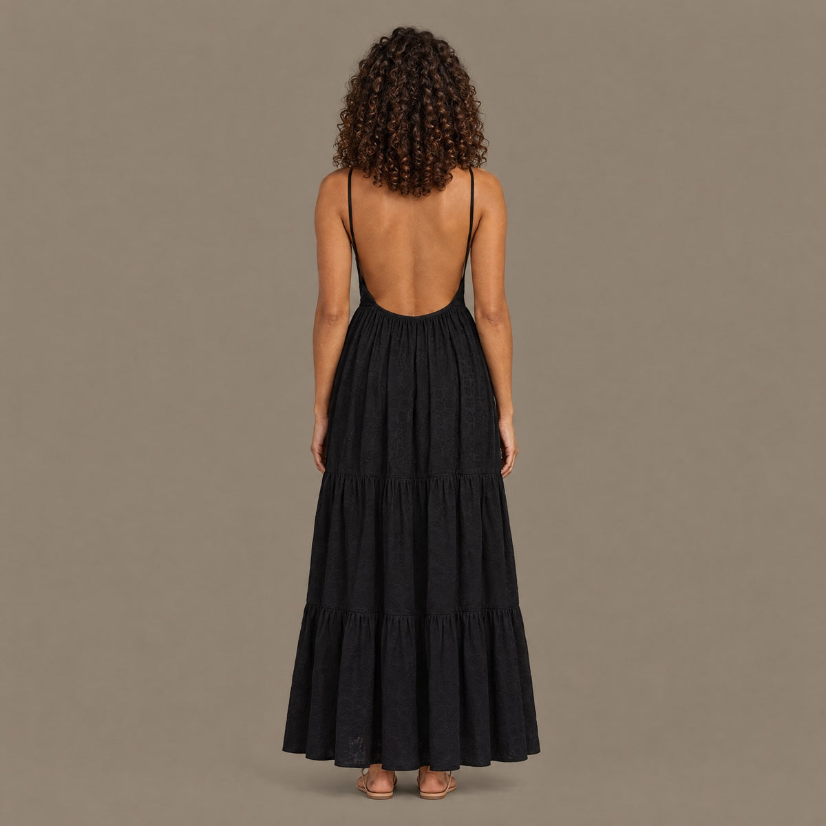 Back view of the black tiered maxi dress showing the open back and fine shoulder straps