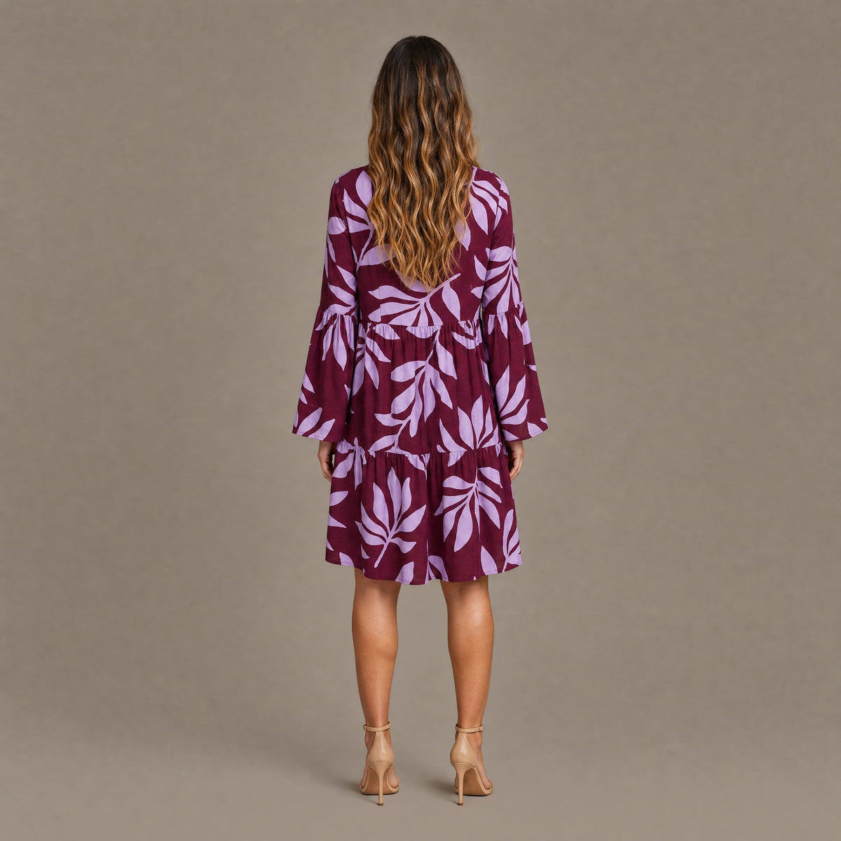 Back view of the burgundy leaf print long sleeve tiered mini dress