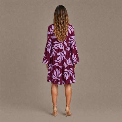 Back view of the burgundy leaf print long sleeve tiered mini dress