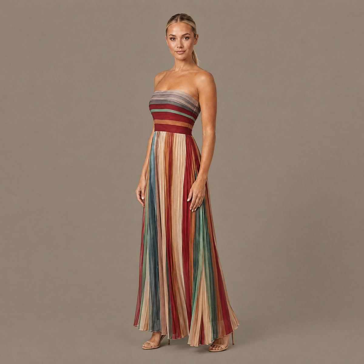 Pleated striped strapless maxi dress seen from a three-quarter angle, showing how the pleats fall